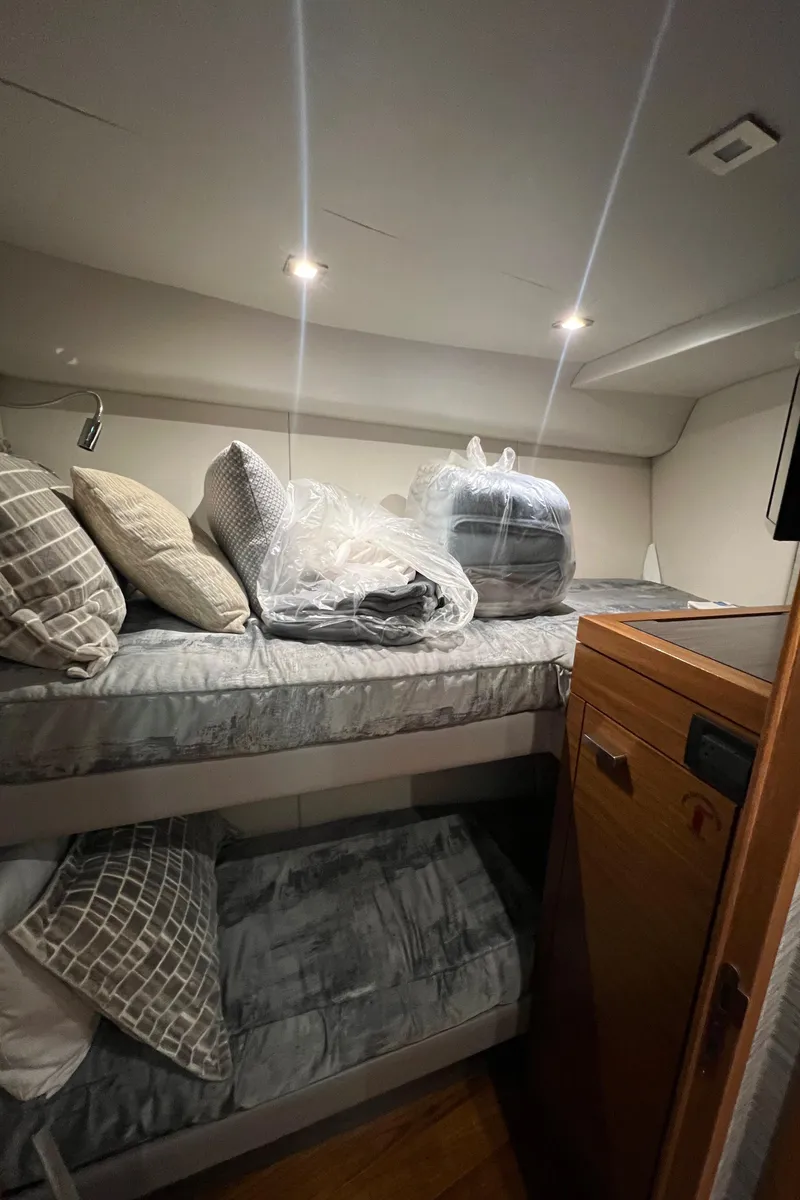 Slide: The Image of 2020 Tiara Yachts C53 Coupe cabin with bunk beds and cozy bedding. - 25