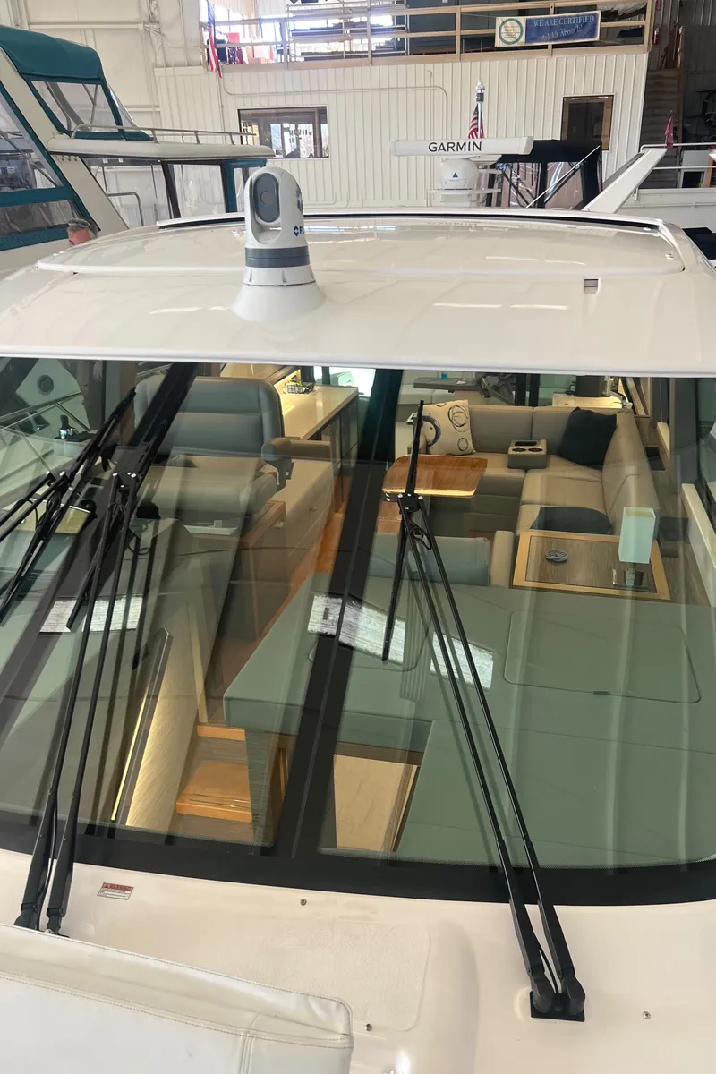 Slide: The Image of 2020 Tiara Yachts C53 Coupe interior view through windshield in a showroom setting. - 28