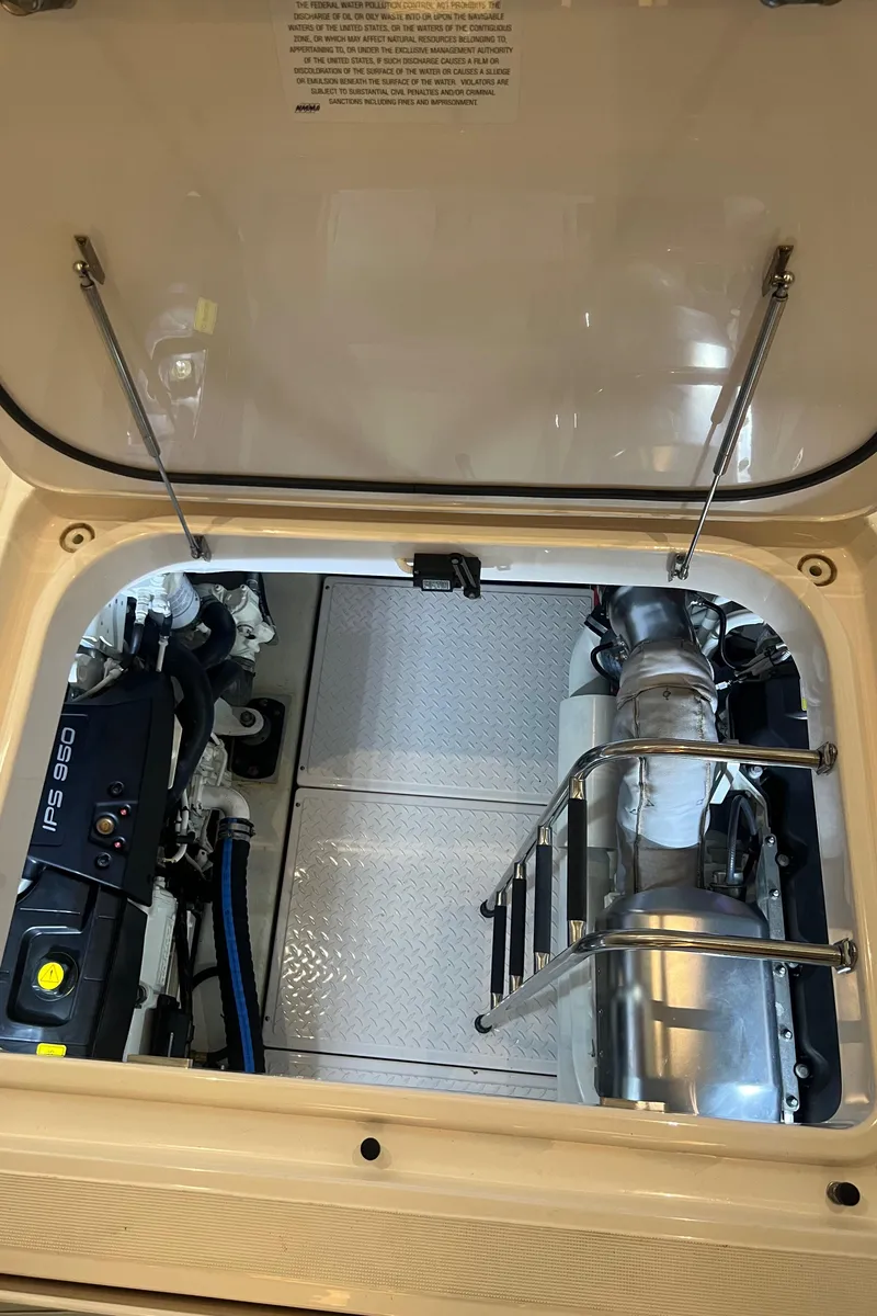 Slide: The Image of Engine compartment of 2020 Tiara Yachts C53 Coupe, showcasing mechanical components and ladder. - 30