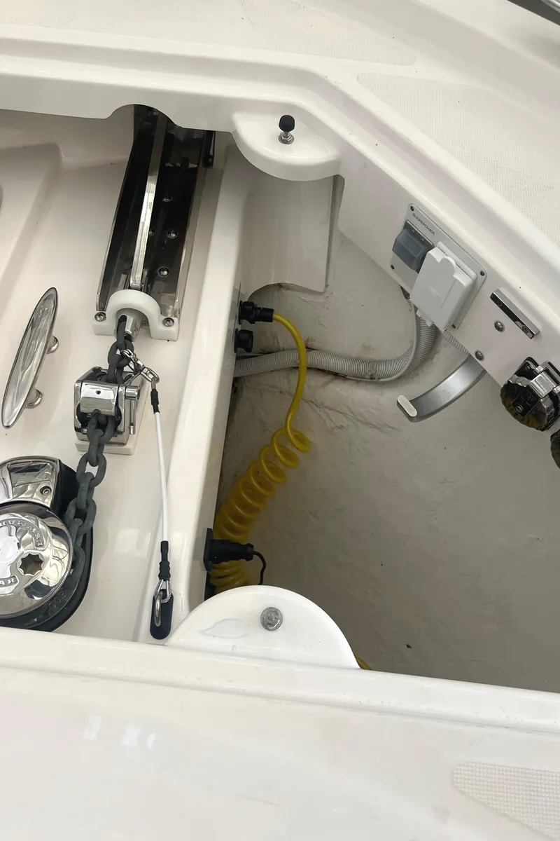 Slide: The Image of 2020 Tiara Yachts C53 Coupe anchor compartment with winch and coiled yellow hose. - 40
