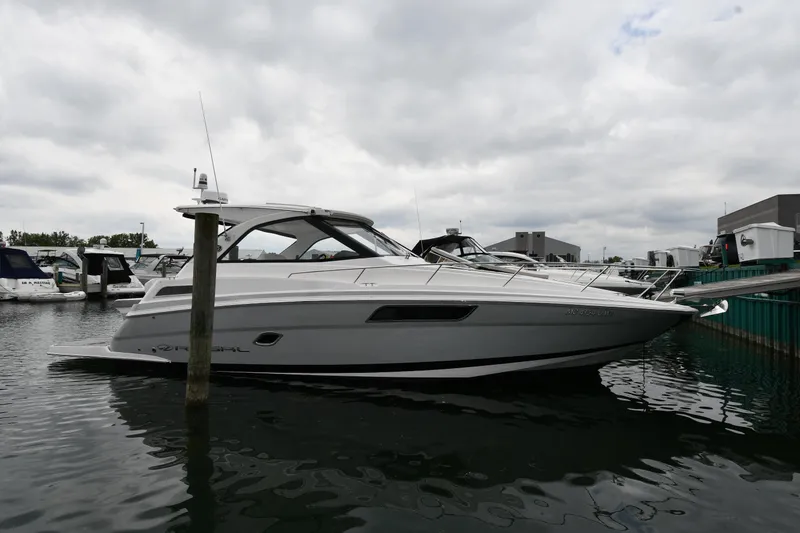 The Image of 2021 Regal 35 Sport Coupe boat docked in a marina under cloudy skies. - 0