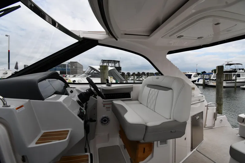 Slide: The Image of 2021 Regal 35 Sport Coupe interior with helm and seating, docked at marina. - 11