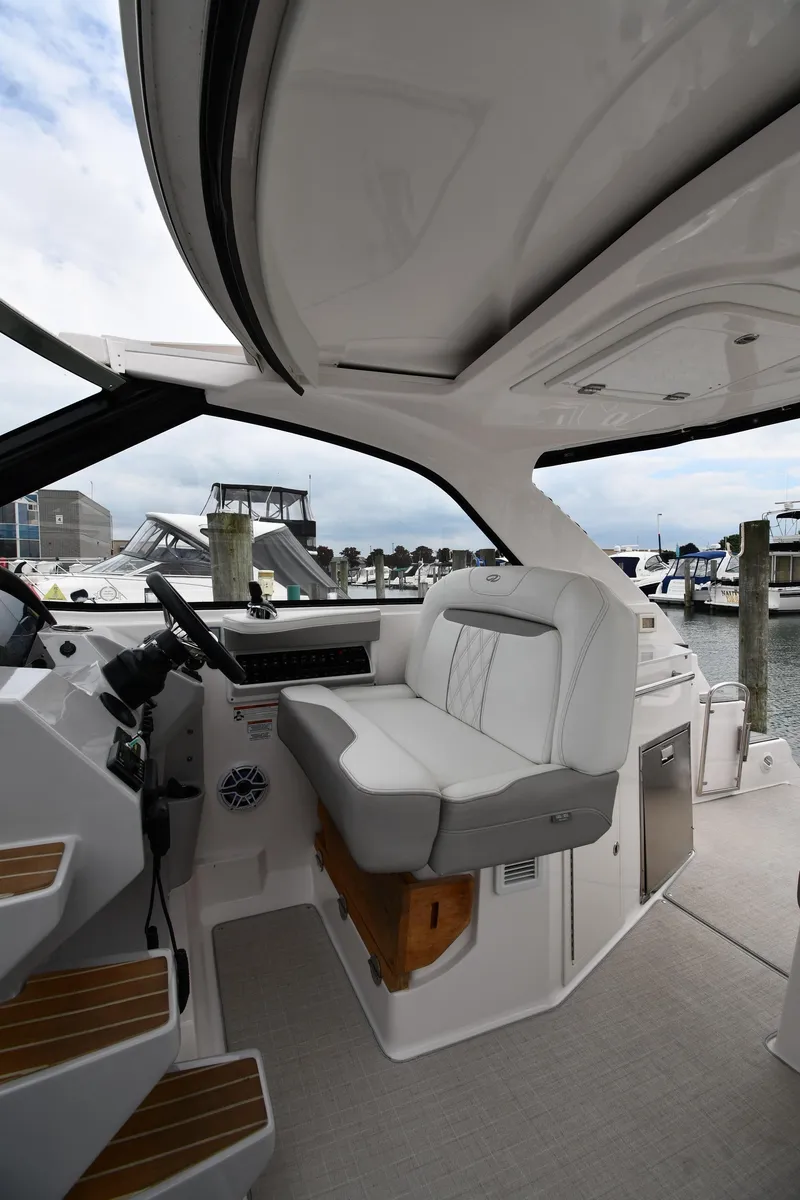 Slide: The Image of 2021 Regal 35 Sport Coupe interior with helm seat, docked at marina. - 12