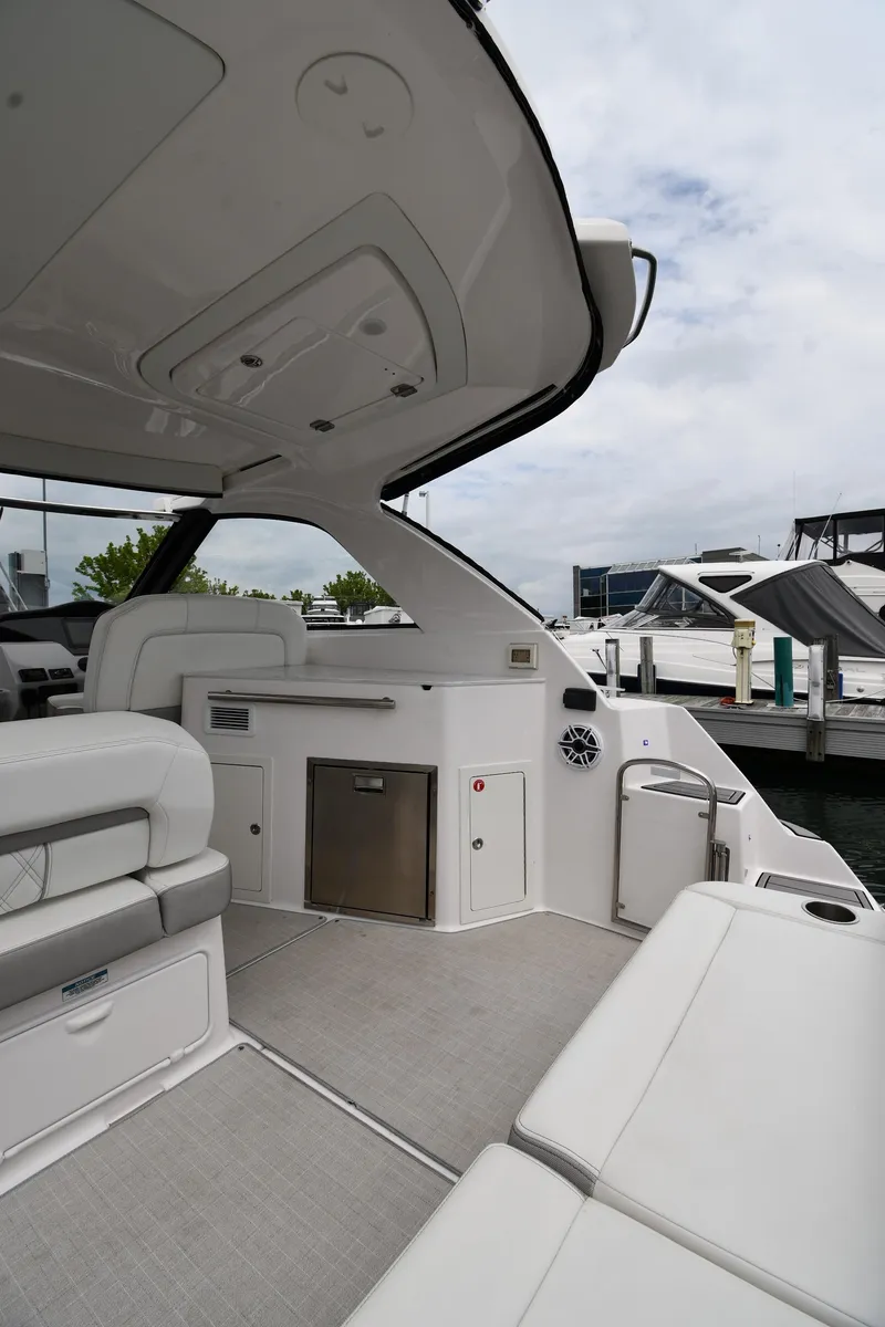 Slide: The Image of 2021 Regal 35 Sport Coupe interior, featuring sleek seating and modern amenities at a marina. - 19