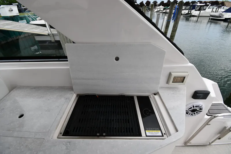 Slide: The Image of 2021 Regal 35 Sport Coupe boat grill area with marina view. - 23
