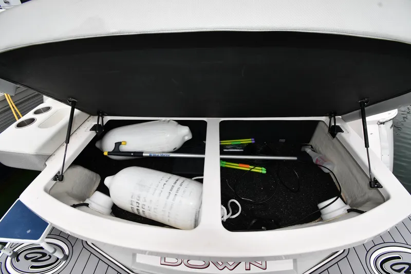 Slide: The Image of Open storage compartment on 2021 Regal 35 Sport Coupe boat with fenders and equipment. - 29