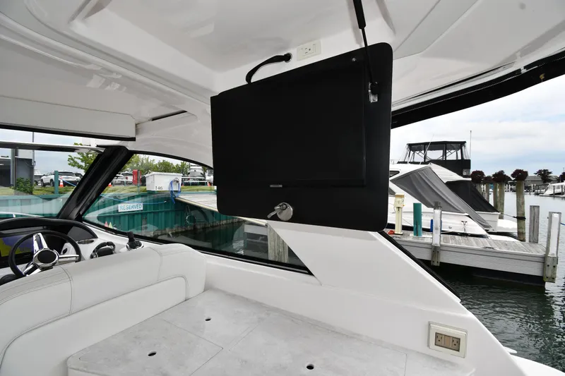 Slide: The Image of 2021 Regal 35 Sport Coupe interior with TV, white seating, and marina view. - 30