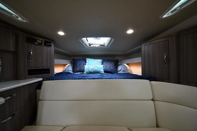 Slide: The Image of 2021 Regal 35 Sport Coupe interior cabin with bed, cushions, and ambient lighting. - 33