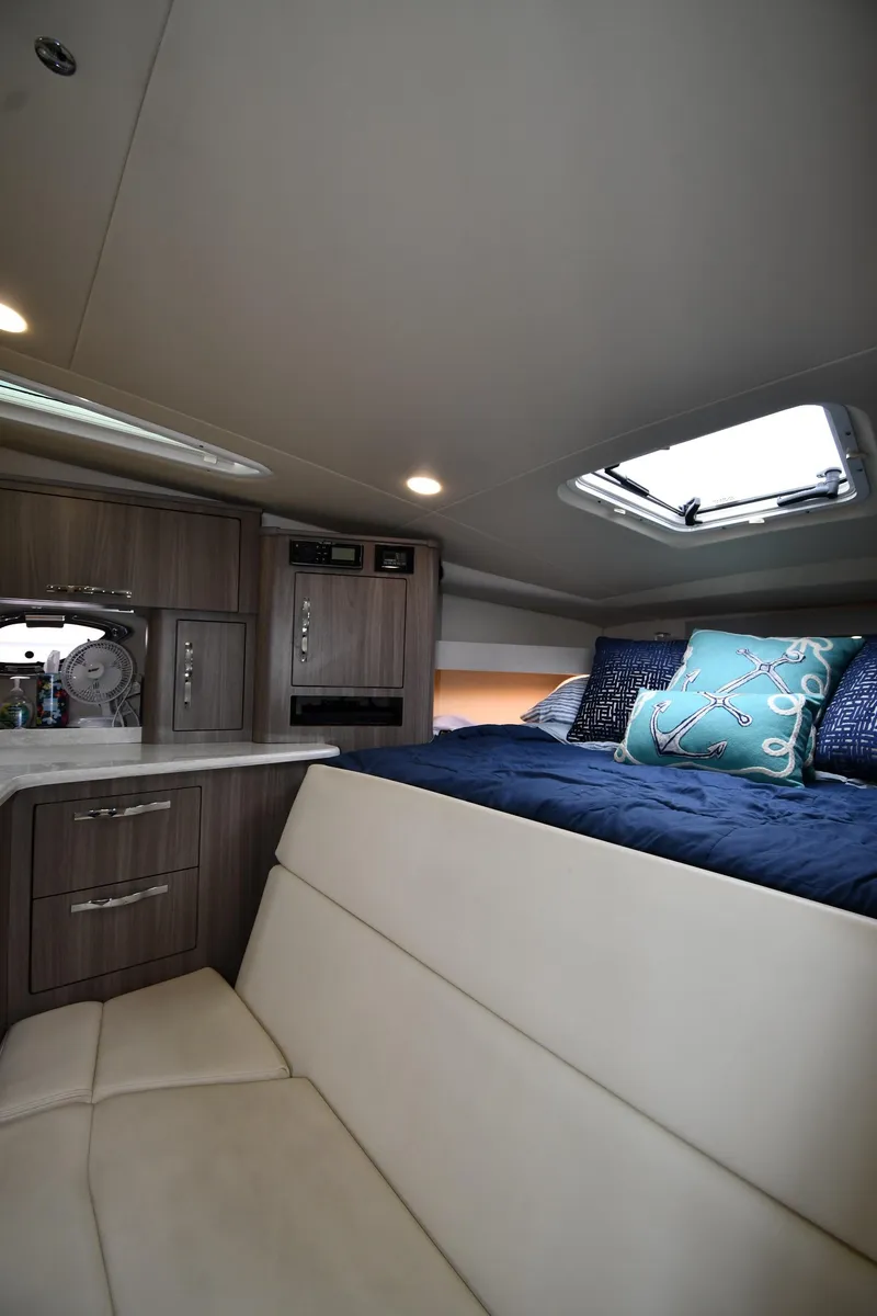 Slide: The Image of 2021 Regal 35 Sport Coupe interior cabin with bed, skylight, and modern cabinetry. - 35