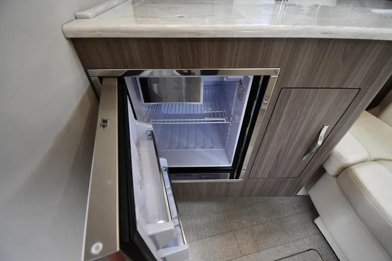 Slide: The Image of 2021 Regal 35 Sport Coupe interior with open mini fridge in wooden cabinetry. - 48