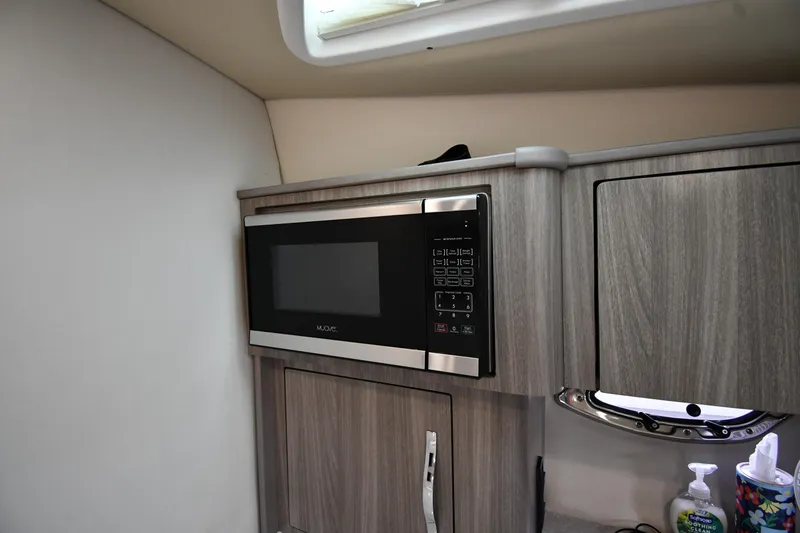 Slide: The Image of Modern kitchen area in 2021 Regal 35 Sport Coupe with microwave and wood cabinetry. - 49
