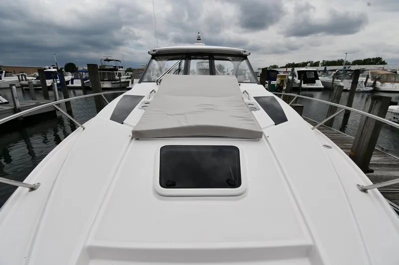 Slide: The Image of 2021 Regal 35 Sport Coupe docked, showcasing sleek design and spacious deck under cloudy skies. - 5