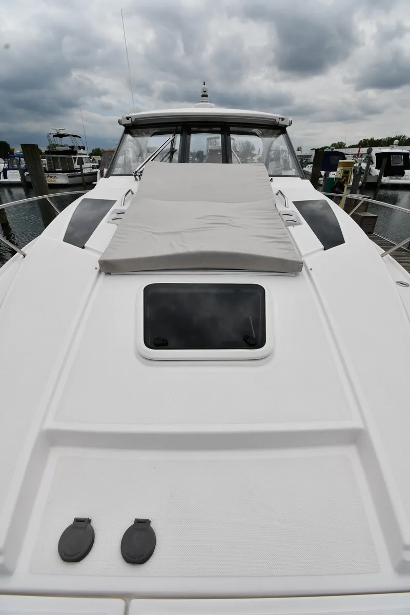 Slide: The Image of 2021 Regal 35 Sport Coupe boat with sleek design, docked under cloudy skies. - 6