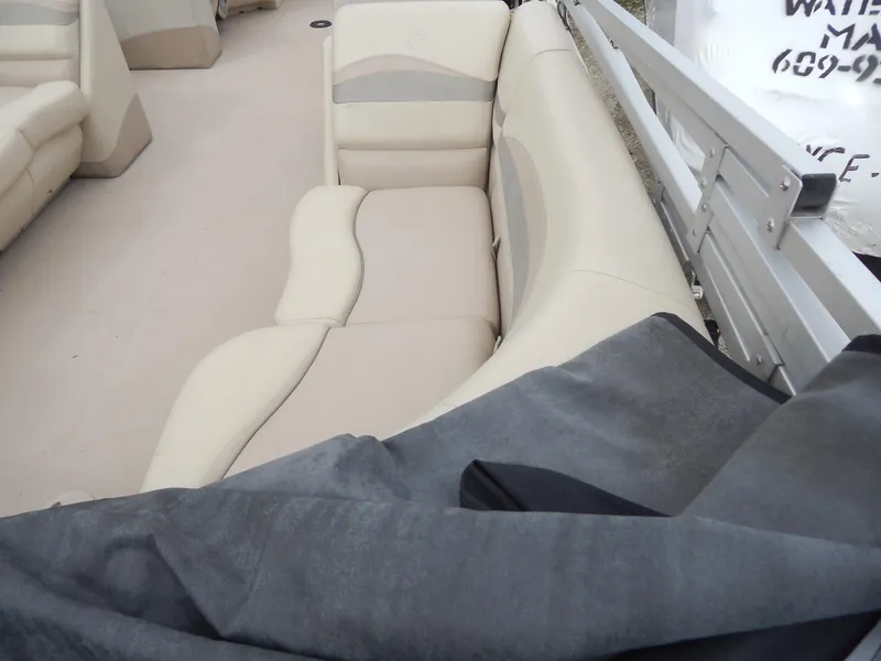 Slide: The Image of 2016 Cypress Cay Seabreeze 230 boat interior with beige seating and protective cover. - 16