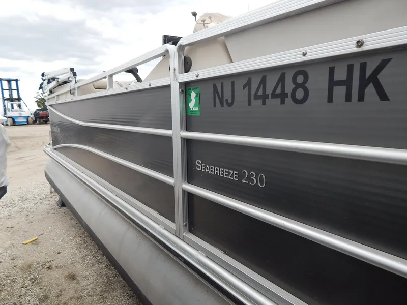 Slide: The Image of 2016 Cypress Cay Seabreeze 230 pontoon boat with NJ registration on a gravel surface. - 2