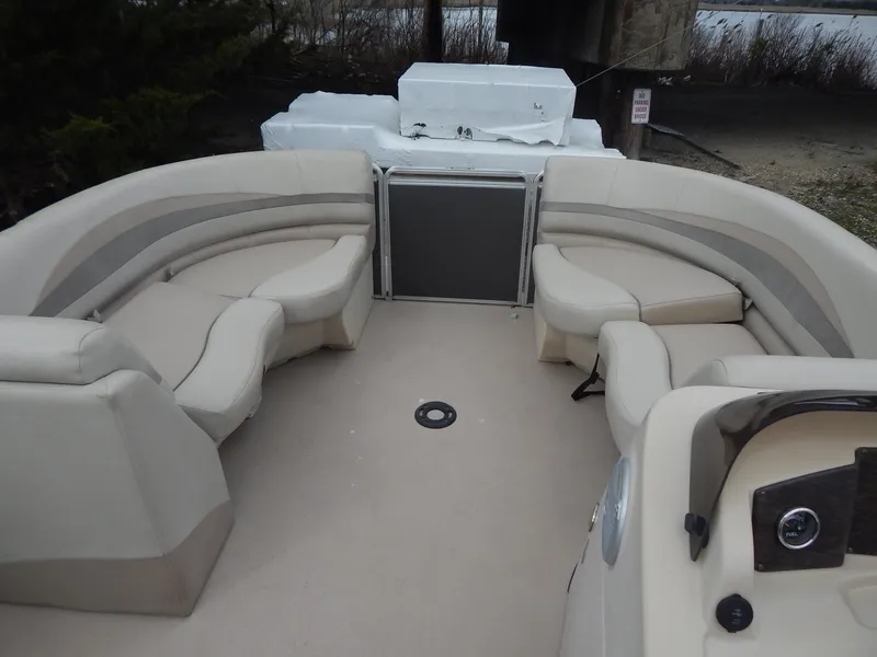 Slide: The Image of 2016 Cypress Cay Seabreeze 230 boat interior with beige seating and open deck space. - 23