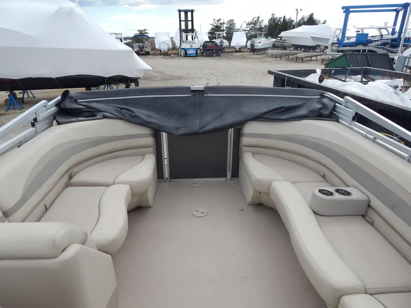 Slide: The Image of 2016 Cypress Cay Seabreeze 230 pontoon boat interior with beige seating and cup holders. - 32