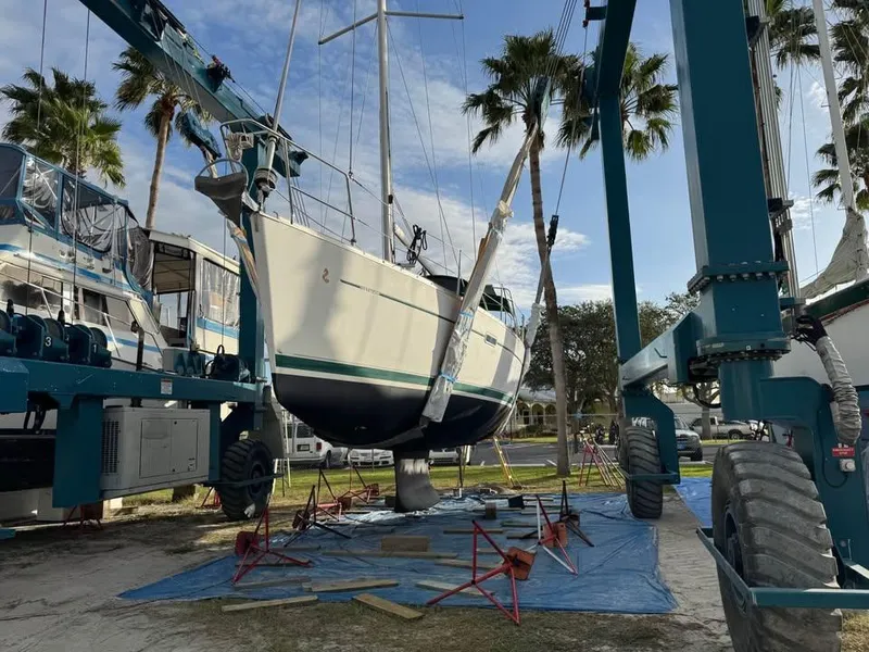 Slide: The Image of 2008 Beneteau Oceanis Clipper 343 sailboat in dry dock, surrounded by palm trees. - 3