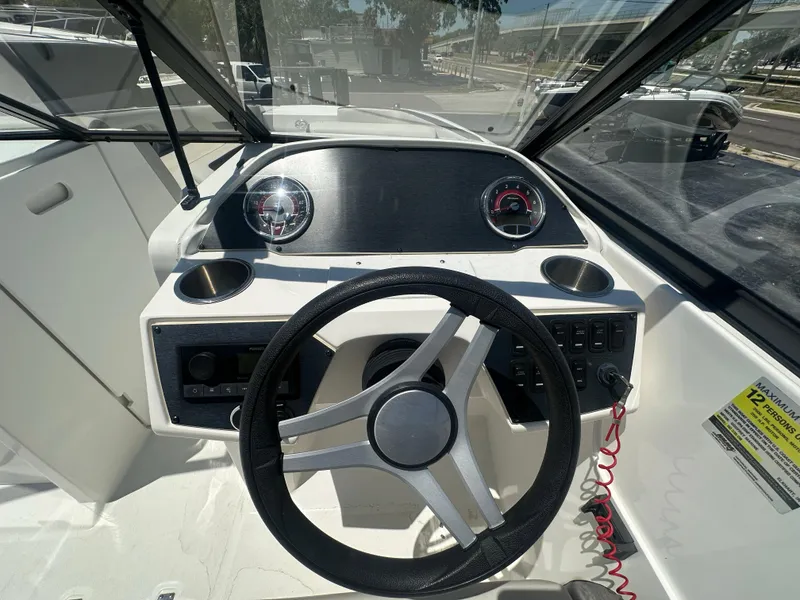 Slide: The Image of 2022 Hurricane SunDeck 235 OB boat dashboard with steering wheel and gauges. - 13