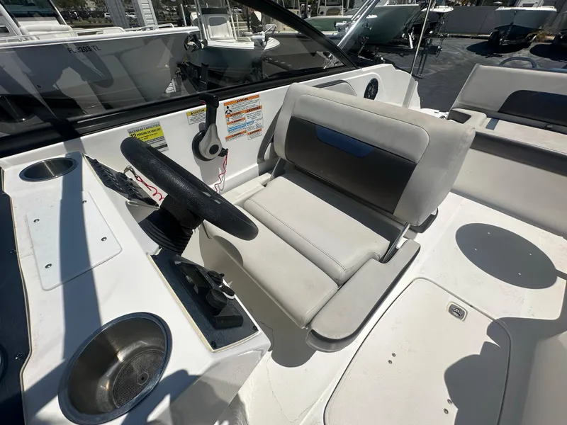 Slide: The Image of 2022 Hurricane SunDeck 235 OB boat interior with steering wheel and seating area. - 19