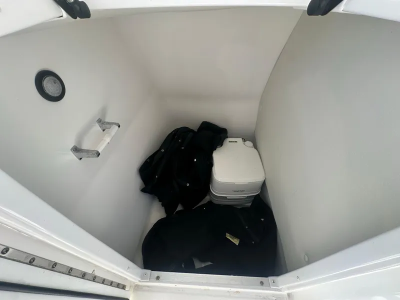 Slide: The Image of Interior storage compartment of 2022 Hurricane SunDeck 235 OB boat with portable toilet. - 21