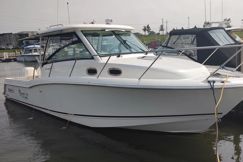 Slide: The Image of 2019 Boston Whaler 315 Conquest boat docked in marina, side view. - 1