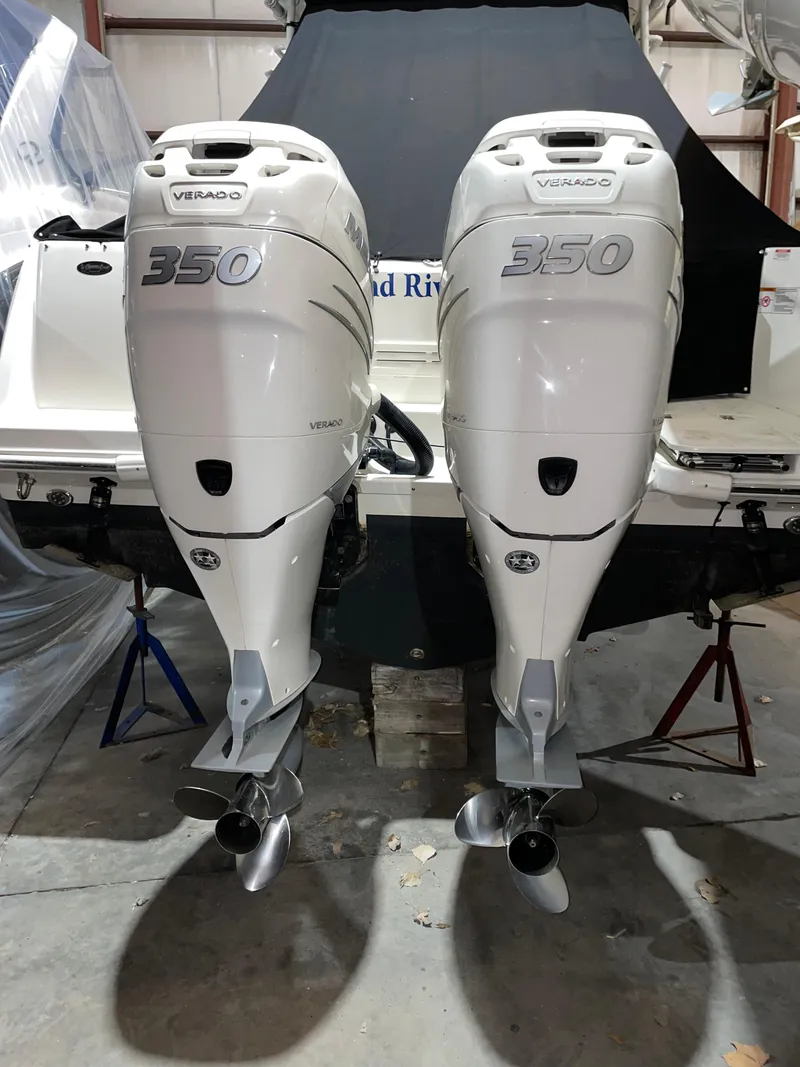 Slide: The Image of 2019 Boston Whaler 315 Conquest with twin 350 Verado outboard engines in a garage. - 24