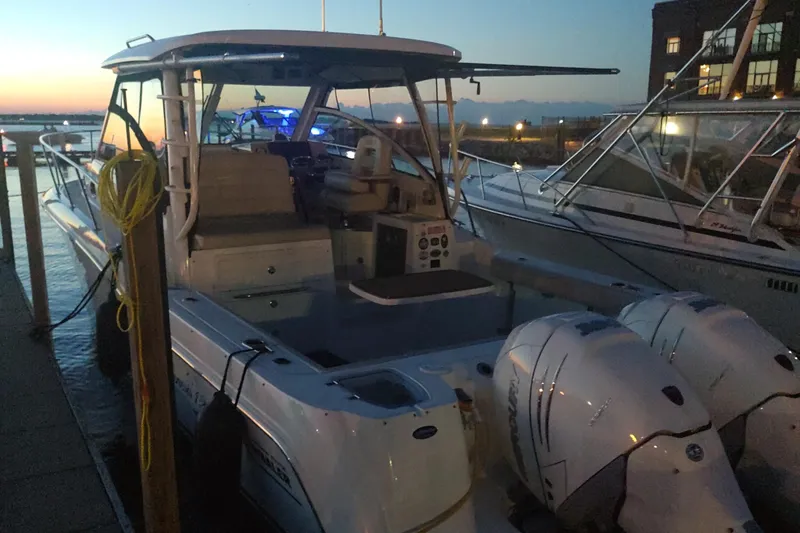 Slide: The Image of 2019 Boston Whaler 315 Conquest docked at sunset with twin engines. - 3
