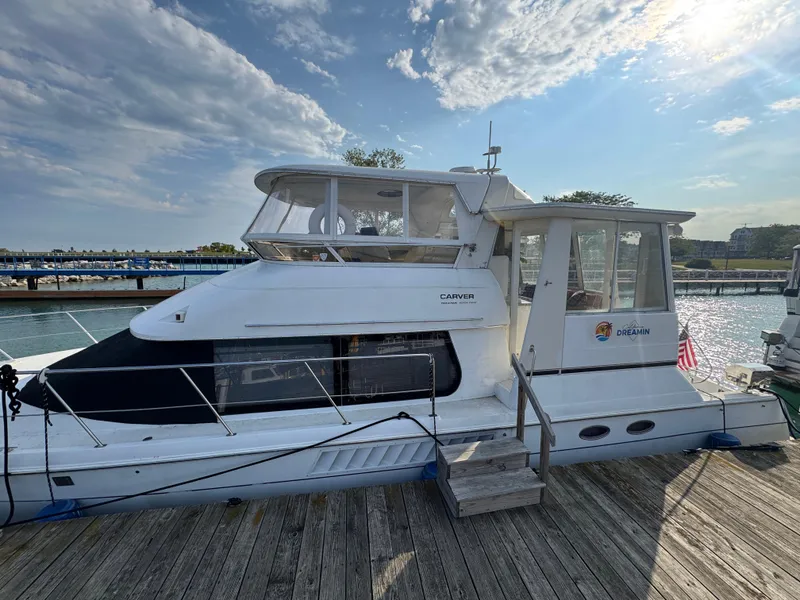 Slide: The Image of 2000 Carver 504 Cockpit Motor Yacht docked at marina under blue sky. - 1