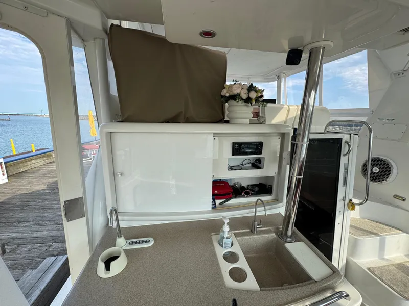 Slide: The Image of 2000 Carver 504 Cockpit Motor Yacht interior with sink, storage, and dockside view. - 12