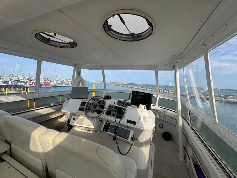 Slide: The Image of Interior view of 2000 Carver 504 Cockpit Motor Yacht helm with marina backdrop. - 17