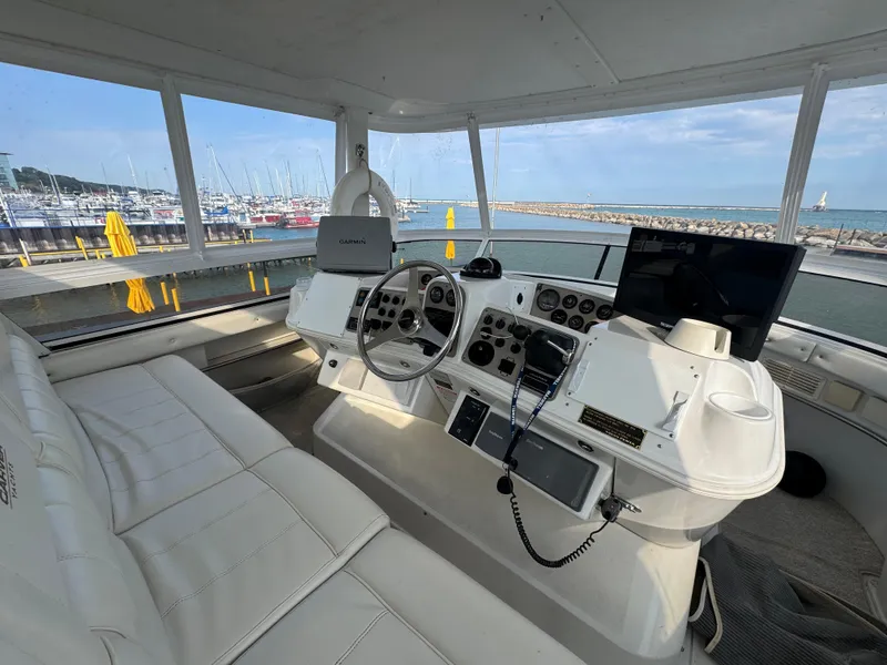 Slide: The Image of Interior view of 2000 Carver 504 Cockpit Motor Yacht helm with marina backdrop. - 18