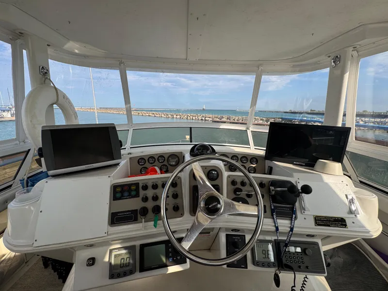 Slide: The Image of Cockpit view of 2000 Carver 504 Cockpit Motor Yacht with navigation equipment and sea backdrop. - 20