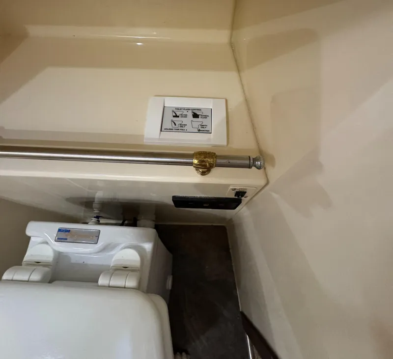 Slide: The Image of Bathroom area in a 2000 Carver 504 Cockpit Motor Yacht, featuring a toilet and safety rail. - 34