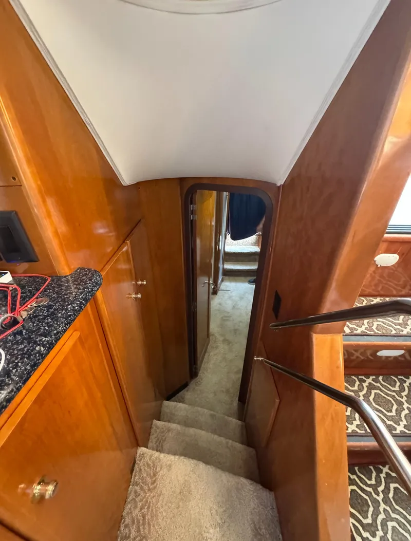 Slide: The Image of Interior view of 2000 Carver 504 Cockpit Motor Yacht with wooden stairs and carpeted flooring. - 41