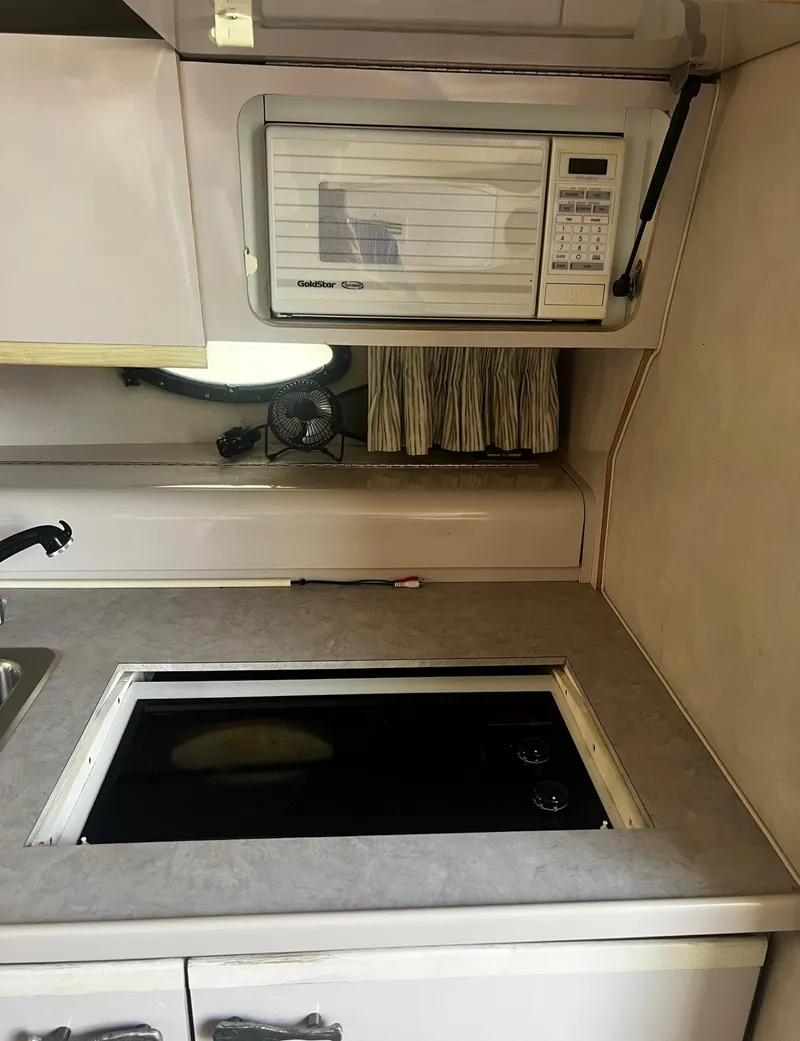 Slide: The Image of 1994 Regal 322 Commodore kitchen with microwave and stovetop. - 20