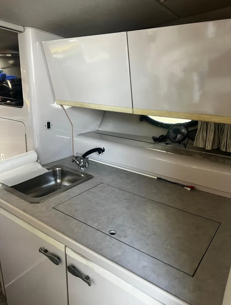 Slide: The Image of 1994 Regal 322 Commodore boat kitchen with sink and storage cabinets. - 21