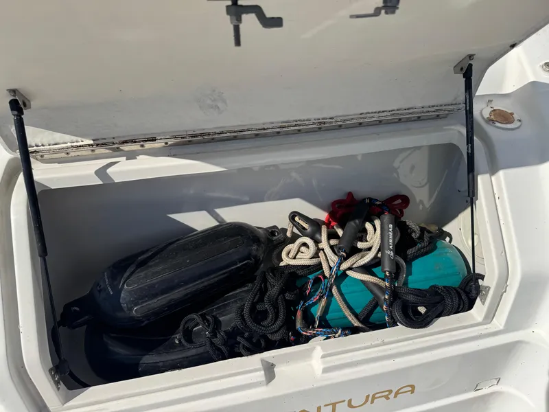 Slide: The Image of Open storage compartment on 1994 Regal 322 Commodore boat with ropes and equipment. - 3