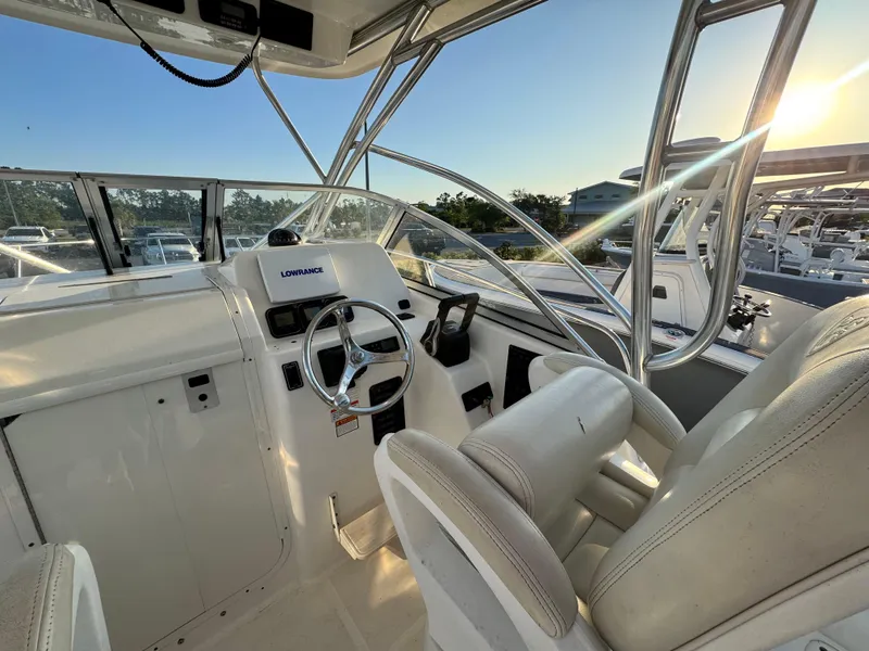 Slide: The Image of 2008 Century 2400 Walkaround boat interior with steering wheel and seating at sunset. - 12