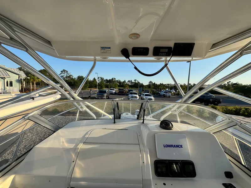 Slide: The Image of 2008 Century 2400 Walkaround boat interior with Lowrance navigation system, parked near vehicles. - 15