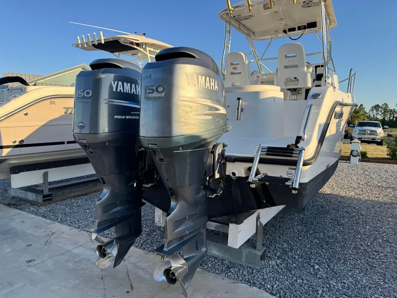 Slide: The Image of 2008 Century 2400 Walkaround boat with twin Yamaha 150 engines, docked on gravel. - 4