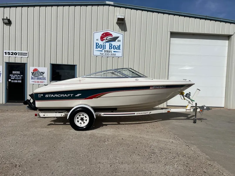 Slide: The Image of 1997 Starcraft 1810 boat on trailer outside Boji Boat Brokers building. - 0