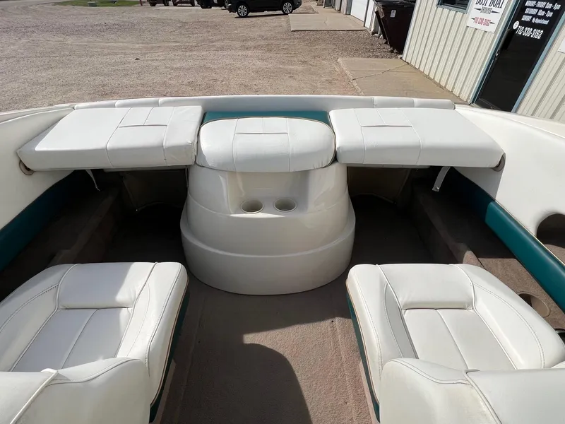 Slide: The Image of 1997 Starcraft 1810 boat interior with white seating and cup holders. - 16