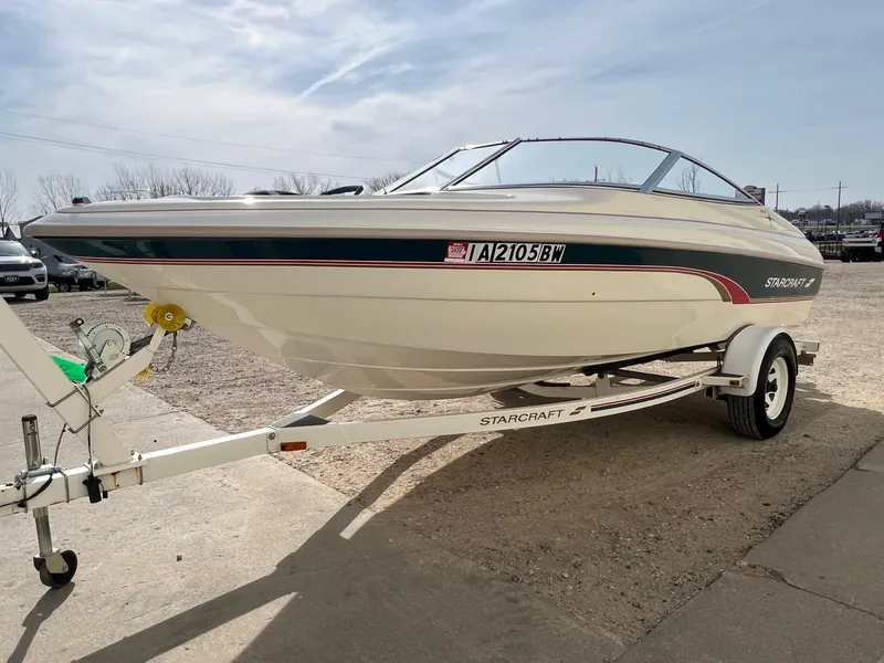 Slide: The Image of 1997 Starcraft 1810 boat on trailer, parked outdoors under a clear sky. - 2