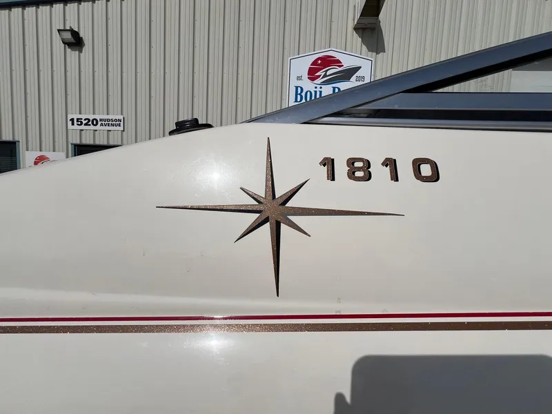 Slide: The Image of 1997 Starcraft 1810 boat with star emblem, parked near Boji Bay building. - 4