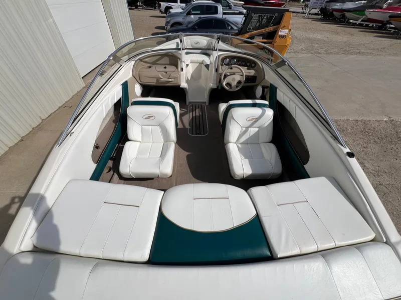 Slide: The Image of 1997 Starcraft 1810 boat interior with white seating and steering wheel, parked outdoors. - 6