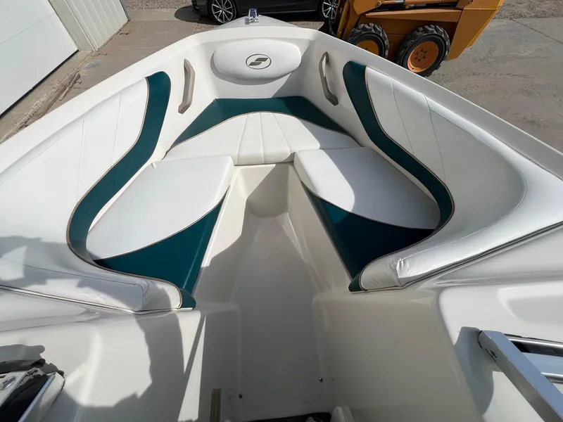 Slide: The Image of 1997 Starcraft 1810 boat interior with white and teal seating, docked outdoors. - 7