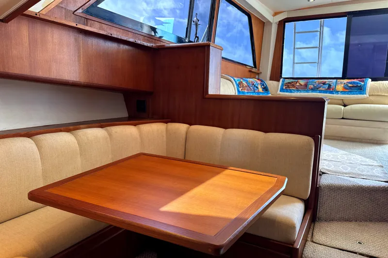 Slide: The Image of Interior of 1990 Viking 38 Convertible yacht with wooden table and beige seating. - 19