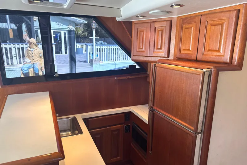 Slide: The Image of 1990 Viking 38 Convertible yacht kitchen with wooden cabinets and modern appliances. - 20