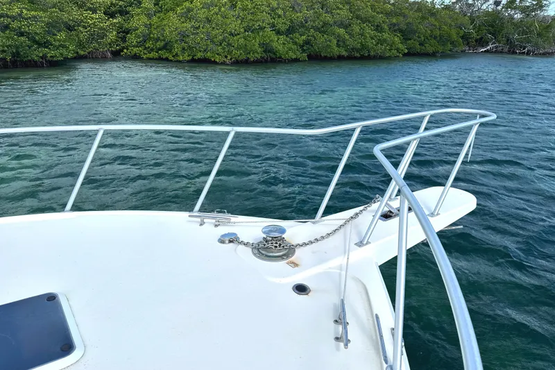 Slide: The Image of Bow of 1990 Viking 38 Convertible boat on calm water near mangroves. - 23